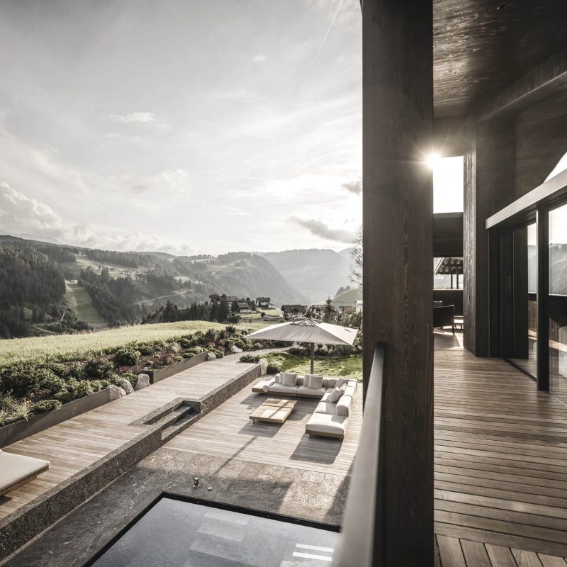 Vista grandangolare dalla terrazza panoramica del solarium, rivelando il panorama e la grandezza della finestra della camera del primo piano all'Chalet Gardena di Cortina Hospitality.