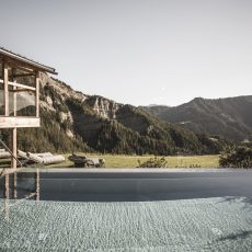 Infinity pool nel giardino paradisiaco dell'Chalet Seceda di Cortina Hospitality, un'esperienza di lusso e serenità senza fine.