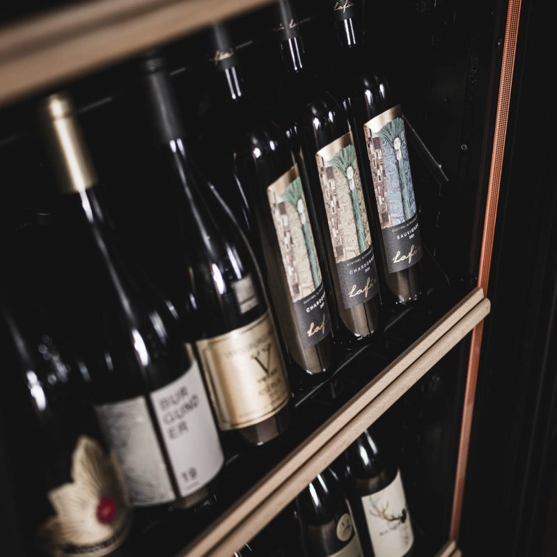 Dettaglio della cantina all'Chalet Gardena di Cortina Hospitality, esprimendo l'eccellenza nella selezione di vini e la tradizione enologica.
