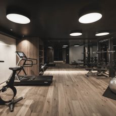 Closeup dei macchinari fitness di design nella sala palestra all'Chalet Gardena di Cortina Hospitality, rappresentando l'eleganza e la funzionalità del contesto fitness.