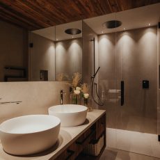 Vista del bagno padronale all'Chalet Sasslong con doppio lavabo e ampia doccia.