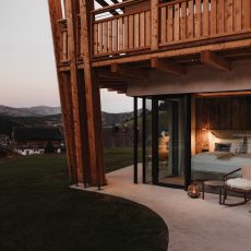 Vista esterna della camera matrimoniale all'Chalet Sasslong con ampia finestra e salottino.