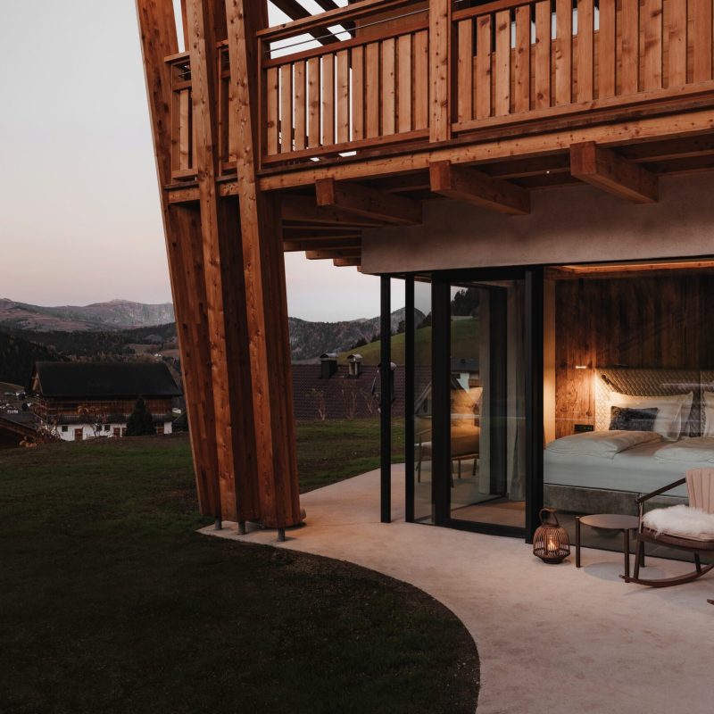 Vista esterna della camera matrimoniale all'Chalet Sasslong con ampia finestra e salottino.