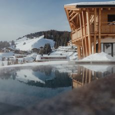 Vista esterna dell'Chalet Sasslong con paesaggio innevato delle Dolomiti
