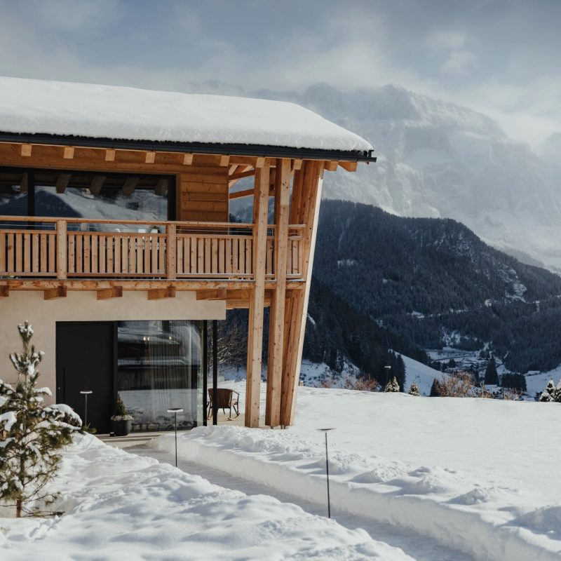 Vista esterna dell'Chalet Sasslong con paesaggio innevato delle Dolomiti